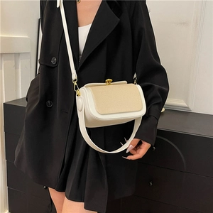 Sac bandoulière bicolore chic en cuir blanc et texture beige sur un mannequin en noir