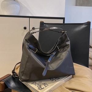 Minimalist large brown tote bag with metal eyelets shown in a stylish home setting