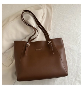 Vista piatta di una borsa tote in pelle opaca marrone scuro con doppi manici e fibbia in metallo