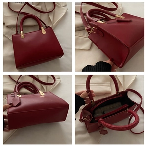 Detail view of burgundy tote bag with interior compartments and gold metal hardware