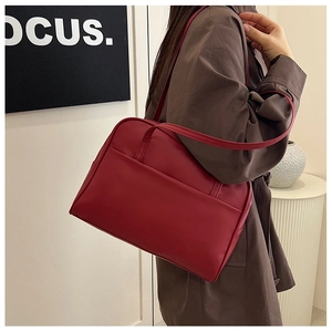 Détail d'un sac à bandoulière vintage rouge foncé en similicuir avec coutures fines