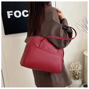 Détail du sac cabas bordeaux avec poche frontale et fermeture éclair sur modèle