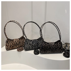 Trois sacs d'épaule à motif léopard en marron, gris et café sur un podium blanc