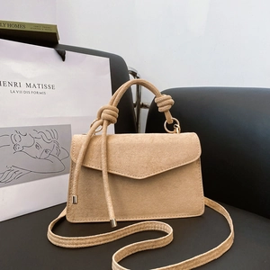 Vintage khakifarbene Wildleder-Umschlagtasche mit Knotengriff und Goldbeschlägen auf Stuhl