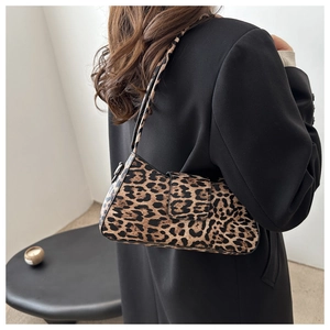 Détail du sac baguette léopard sur l'épaule avec blazer noir pour un style d'hiver