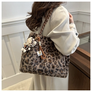Detail of plush leopard print tote bag with soft faux fur texture and bear charm accessory