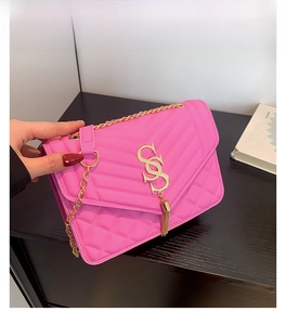 Detailed view of pink chain crossbody bag with V-shaped quilting and gold tassel