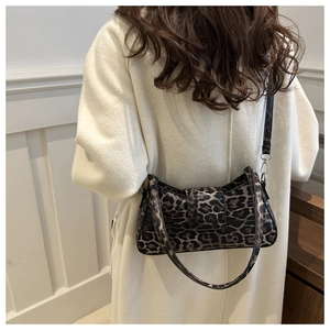 Detailansicht der modischen Schultertasche mit Leopardenmuster, getragen von einem Model