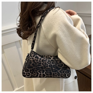 Détail d'un sac demi-lune à imprimé léopard vintage porté à l'épaule par un mannequin
