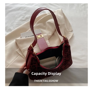 Detail view of red leopard print handbag interior capacity with faux leather strap