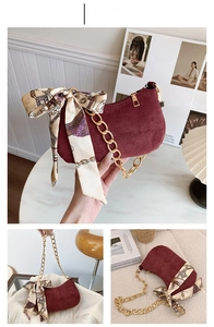 Dettaglio borsa bordeaux opaca con catena dorata e foulard di seta decorativo