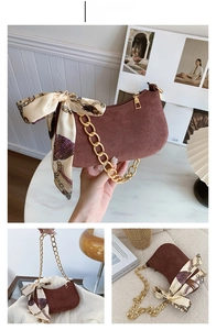 Dettaglio borsa scamosciata caffè con catena dorata spessa e foulard di seta chic