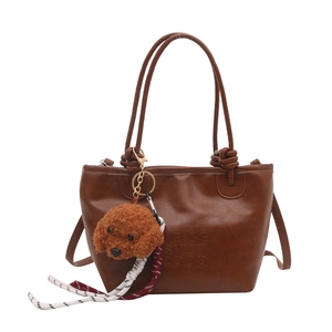 Vintage brown leather tote bag with poodle plush charm and woven rope tassel detail