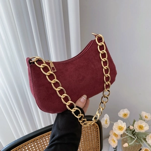 Vintage burgundy suede crescent bag with a bold gold chain strap for stylish women