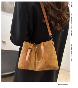 Detail of vintage matte brown tote bag in suede texture with elegant leather strap