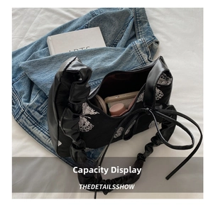 Interior view showing the storage capacity for lipstick and phone in a black butterfly bag