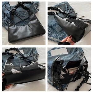 Detailed views of black leather crescent bag with white butterfly embroidery and ruched strap