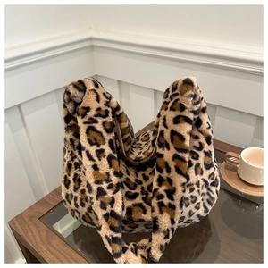 Close-up of leopard print faux fur shoulder bag texture on a stylish glass table