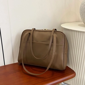 Grand sac fourre-tout minimaliste marron café en similicuir sur un banc en bois