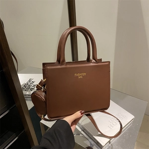 Minimalist dark brown tote bag with top handles and matching round coin purse detail