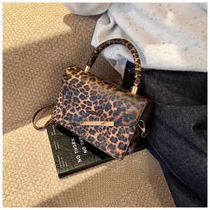 Détail du sac à bandoulière léopard avec boucle en métal doré et bandoulière en cuir