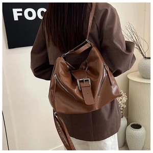 Detailed view of caramel brown vintage tote bag with buckles and silver zippers