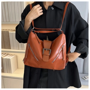 Detail of vintage caramel leather tote bag featuring dual zippers and belt buckle design