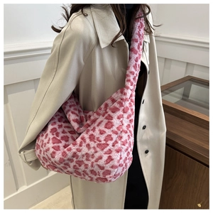 Detail of pink leopard print plush tote bag with soft faux fur texture on beige coat