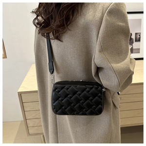 Fashionable black quilted box bag with double zippers and detachable shoulder strap on model