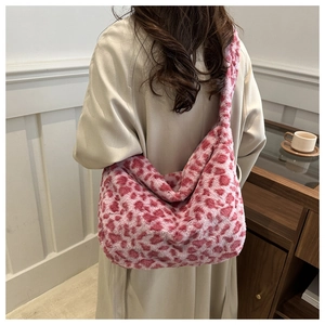 Detailed close-up of pink leopard print plush tote bag worn over a beige winter coat