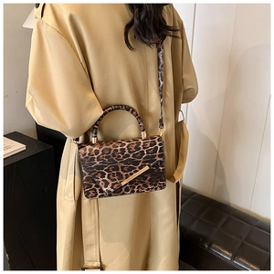Détail d'un sac à bandoulière léopard élégant avec des garnitures dorées sur modèle