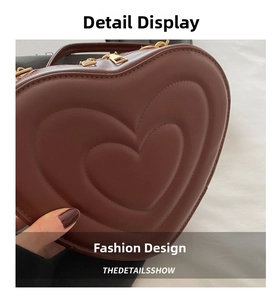 Detail of heart-shaped handbag with multi-layer embossed leather and gold zipper