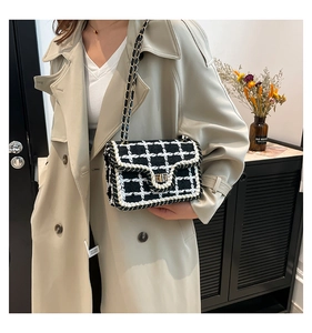 Dettaglio della borsa a tracolla in tweed intrecciato bianco e nero con catena dorata
