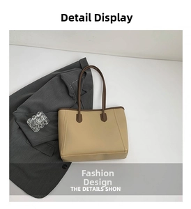 Detail view of large tote bag with brown straps paired with a grey blazer and accessories