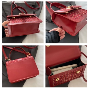 Detail view of red tweed crossbody bag showing interior space and golden metal clasp