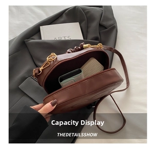 Interior view showing the capacity of a dark brown faux leather arched crossbody bag