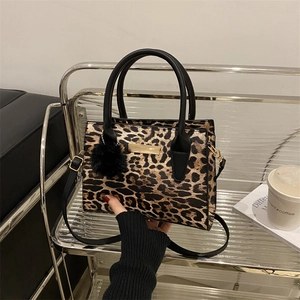 Trendy leopard print crossbody handbag with gold hardware and black pompom accessory
