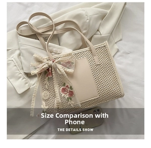 Detail shot of straw tote bag showing size comparison with smartphone on white blazer