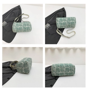 Macro view showing the green and white striped woven texture of this cylinder shoulder bag