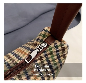 Macro view of retro tartan fabric and polished silver zipper detail on shoulder bag