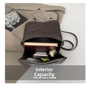 Internal capacity of dark brown leather crossbody bag with books and cosmetics items