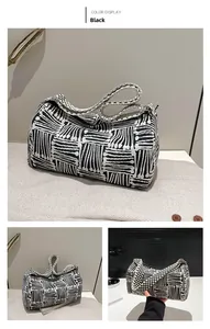 Detail of black and white striped knit hobo bag with wide woven strap and zipper