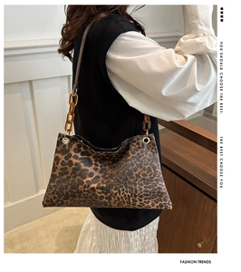 Detail of leopard print tote bag with stylish amber acrylic chain and dark brown strap