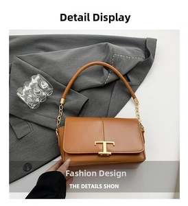 Détail d'un sac bandoulière en cuir marron avec boucle en T dorée et bandoulière chaîne