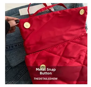Détail de la fermeture magnétique et du motif matelassé sur un sac rouge