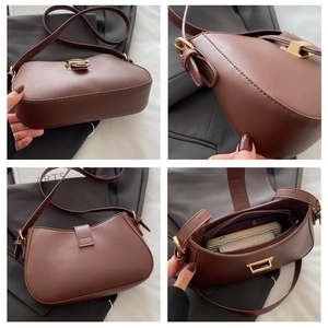 Detail view of brown shoulder bag showing golden clasp, side lines and inner zip pocket