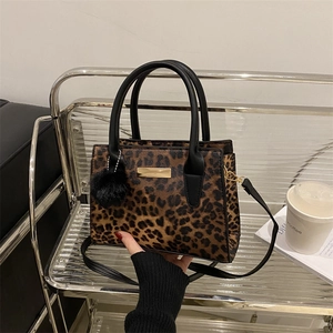 Fashionable leopard print handbag with black handles and detachable shoulder strap