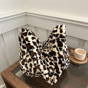 Chic leopard print plush shoulder bag on a wooden table with casual lifestyle aesthetic