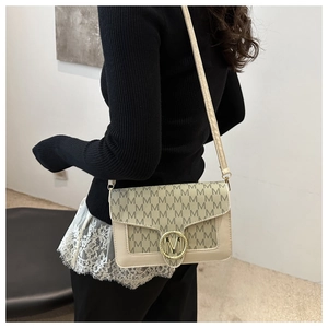 Détail du monogramme M et de la boucle en métal doré sur le sac à bandoulière élégant