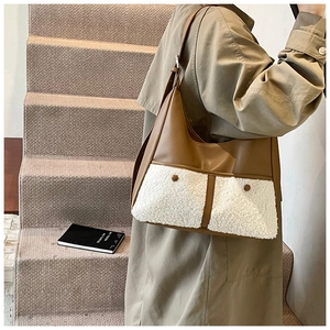 Detail of a large contrast tote bag with brown leather and white faux shearling pockets